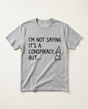 Not Saying Its A Conspiracy But tinfoil-hat doodle tee, flat-lay on bone background